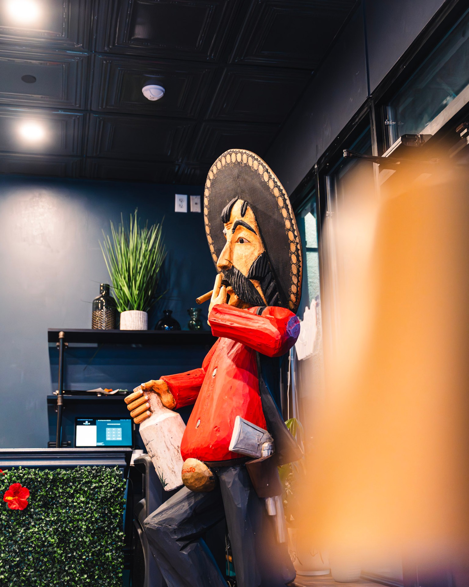 Hand-carved wooden sombrero statue at the entrance